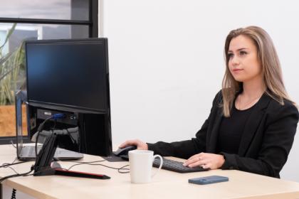 Kvinde står og arbejder ved en computer
